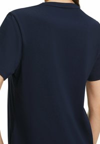 T-shirt blu navy, maniche corte, texture liscia, colletto a girocollo, design minimalista, con una vista posteriore semplice e senza motivi o accenti visibili.