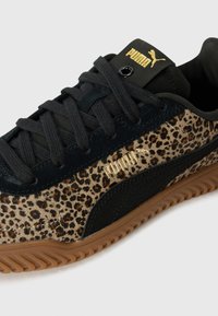 Sneaker Puma con un design a stampa leopardata, in accoppiamento con dettagli in suede nero, lacci scuri e suola in gomma color caramello. Logo dorato sulla linguetta.