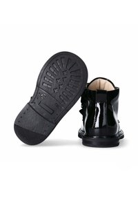 Stivaletti alla caviglia in pelle verniciata nera con suola in gomma testurizzata, caratterizzati da un dettaglio con fibbia, punta rotonda e morbida fodera interna.