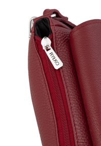 Borsa in pelle bordeaux con finitura testurizzata, dotata di una cerniera argentata con il nome del marchio. La vista laterale mostra l'imbottitura in tessuto e i dettagli della cerniera.