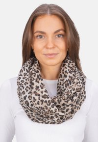 Écharpe en tissu léger à motif léopard, avec des nuances de beige et de noir, dotée d'une texture douce et d'un design en boucle continue.