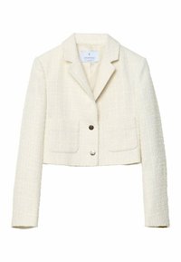 Veste courte en tweed de couleur crème avec un col cranté, deux poches avant et deux boutons métalliques au centre.