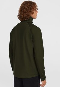 Pullover verde scuro con collo alto, maniche lunghe e una texture liscia, caratterizzato da cuciture a contrasto lungo le cuciture.