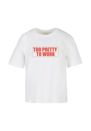T-shirt bianco in cotone con maniche corte. Presenta un testo rosso audace "TROPPO BELLA PER LAVORARE" all'interno di un contorno rettangolare. Vestibilità casual e larga.