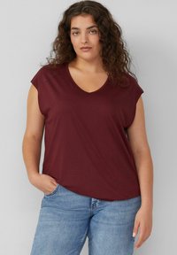 Bordeaux T-shirt met korte mouwen en V-hals van zachte stof, gecombineerd met lichte spijkerbroek. Eenvoudig design, ontspannen pasvorm.