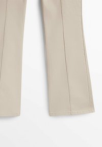Pantalons larges beiges en tissu lisse, au design ajusté avec des plis et un ourlet bien fini.