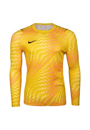 Maglia sportiva gialla a maniche lunghe con motivi a zigzag rosa e logo Nike Swoosh nero sul petto superiore sinistro.
