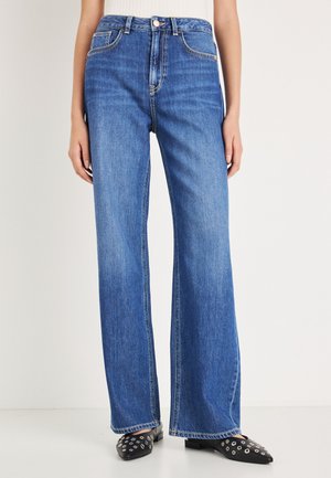 Jeans larghi in denim blu a vita alta con finitura sbiadita, caratterizzati da una struttura tradizionale con cinque tasche e dettagli di cuciture sottili.