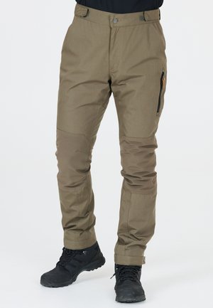 Khaki outdoor broek gemaakt van duurzaam, gestructureerd materiaal; beschikt over versterkte kniestukken en een zijrits zak. Gekoppeld met zwarte wandelschoenen.