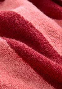 Textured towel with alternating stripes in light pink and dark red, showcasing a soft, plush surface and a woven, absorbent design.