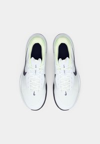 Ζευγάρι άσπρων και μαύρων αθλητικών παπουτσιών Nike με κορδόνια, απεικονισμένα από πάνω σε λευκό φόντο.