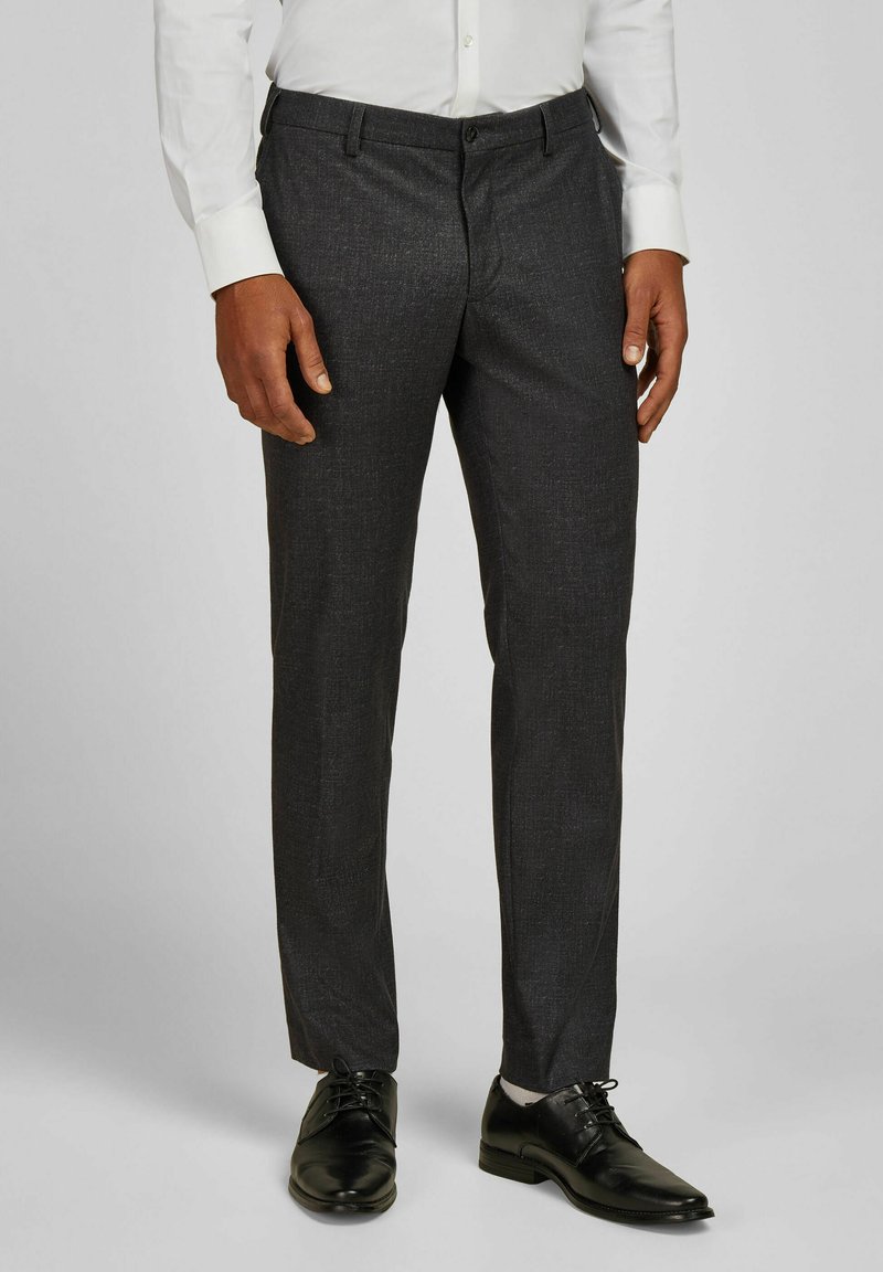 Grijze op maat gemaakte broek met een subtiele textuur, met een rechte pijpontwerp en in contrast met zwarte nette schoenen.