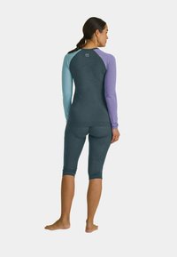 Blue and purple long-sleeve rash guard with a fitted design, made of stretch fabric, paired with matching cropped leggings.