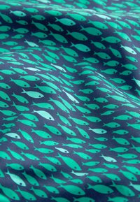 Tessuto con uno sfondo blu navy decorato con numerosi piccoli pesci turchesi e azzurri che nuotano in un motivo vorticoso.