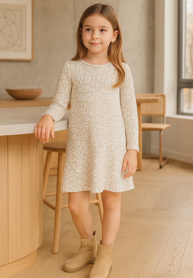 Langärmliges cremefarbenes Kleid mit floralem Muster, A-Linien-Form und weicher Textur, kombiniert mit sandfarbenen Ankle Boots. Einfaches und komfortables Design.