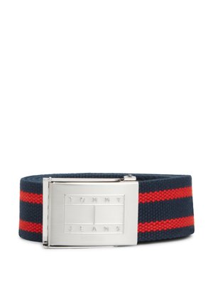 Ceinture en tissu bleu marine avec deux rayures rouges horizontales et une boucle rectangulaire argentée gravée du logo "Tommy Jeans".