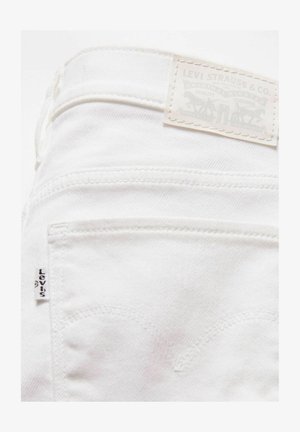 Witte denim jeans met een achterzak, voorzien van kenmerkende stiksels en een tan leren label met de opdruk "Levi Strauss & Co."