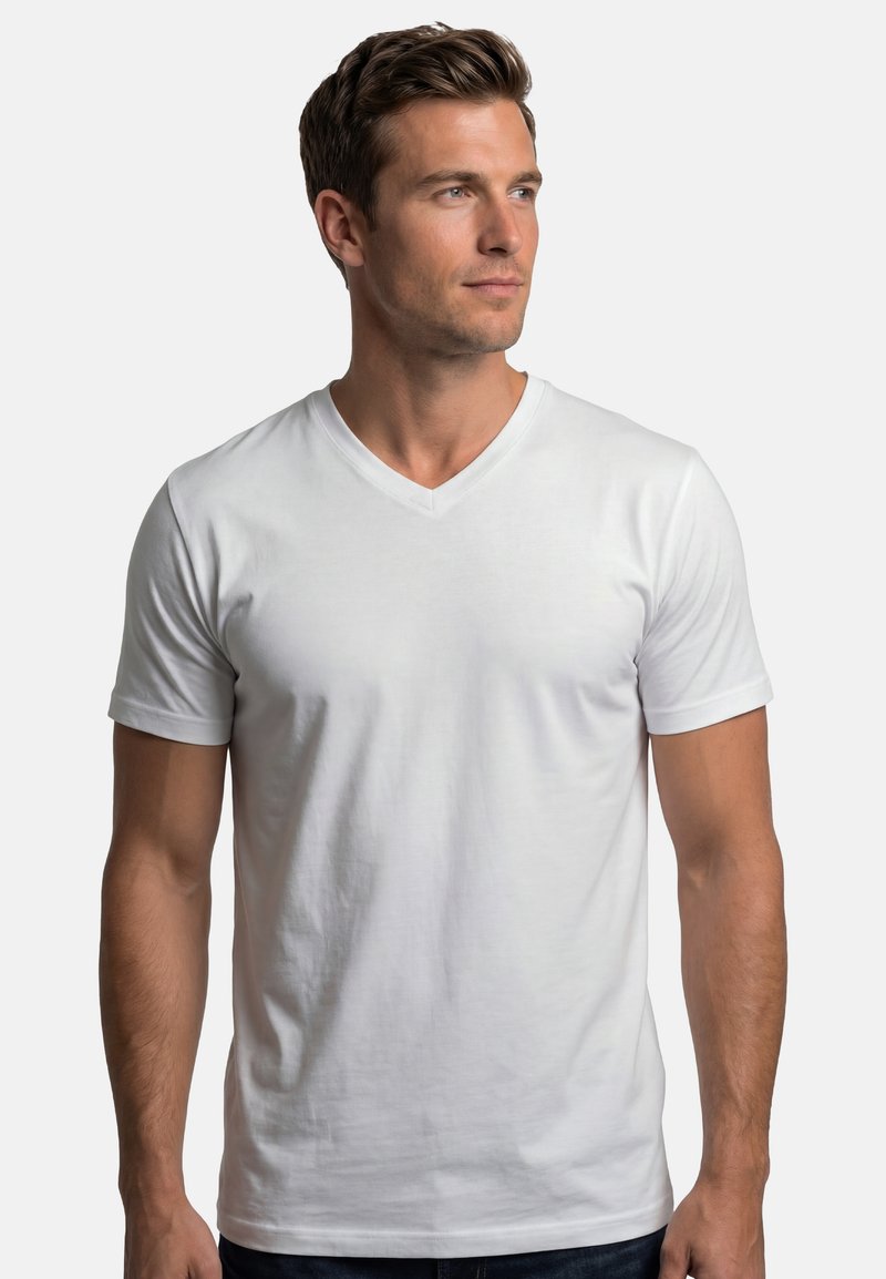 Homme aux cheveux bruns courts portant un t-shirt blanc uni à col en V et manches courtes, regardant vers la droite sur un fond gris clair.