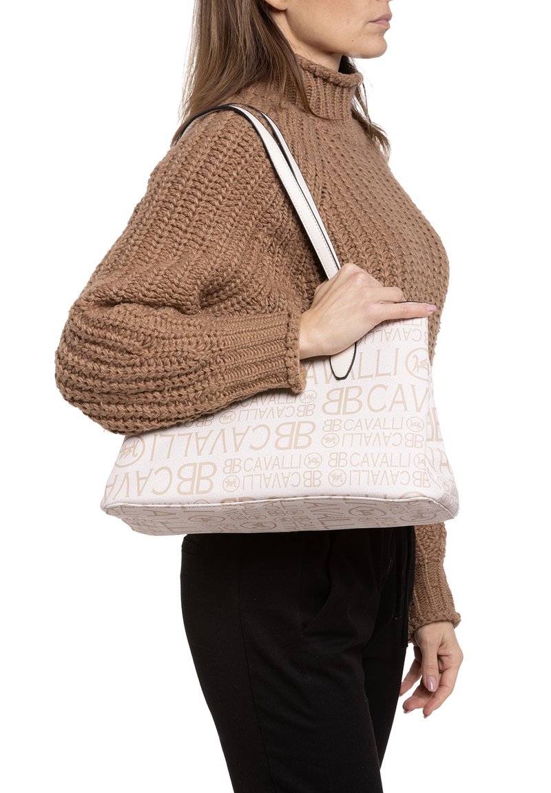 Beige schoudertas met een reliëflogo-patroon, rechthoekige vorm, textielstof en twee contrasterende zwarte handvatten.