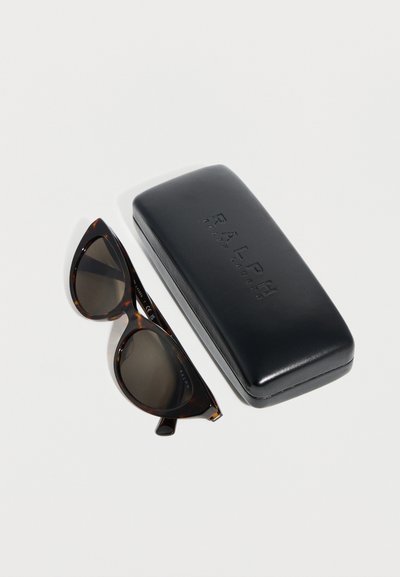 Skildpaddeskæl katteøje-solbriller med mørke linser ved siden af et sort Ralph Lauren hårdtui på en hvid overflade.