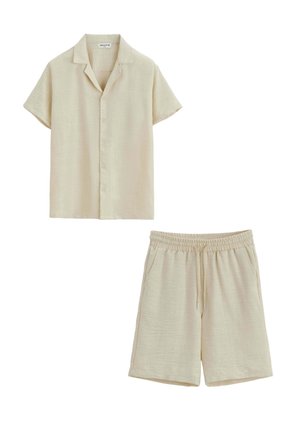 Chemise beige à manches courtes boutonnée avec col, associée à un short beige taille élastique avec cordon et poches latérales.