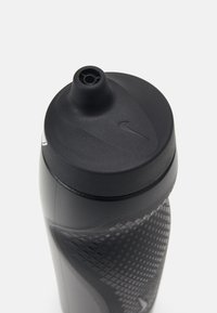 Zwarte sportwaterfles met een gestructureerde matte afwerking, een taps toelopende vorm, een zwarte dop en een Nike-logo nabij de bovenkant.