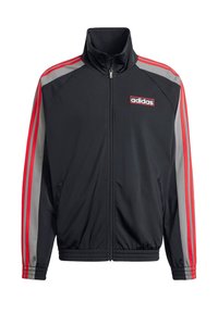Chaqueta de chándal negra con cuello alto y cremallera completa. Presenta acentos en tres rayas rojas y grises en las mangas y un logo de Adidas en el pecho.
