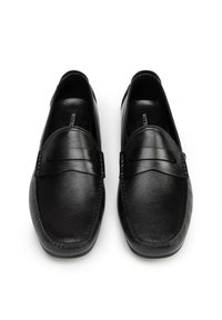 Mocasines de piel negra con un acabado texturizado, que presentan un estilo de mocasín cosido y sutiles acentos decorativos en la parte superior.