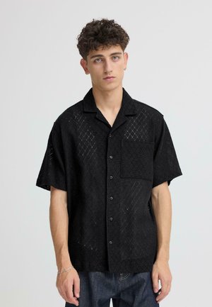 Schwarzes Kurzarmhemd aus strukturiertem, offenem Strickstoff, mit Kragen, durchgehender Knopfleiste, einer Brusttasche und Rautenmuster.