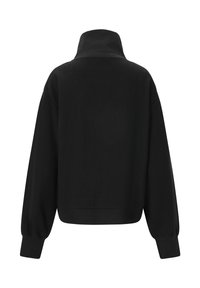 Schwarzer gerippter Pullover mit hohem Kragen, kastiger Form und Ballonärmeln. Weiche Textur in einheitlicher Farbe ohne sichtbare Muster oder Akzente.