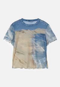 Gjennomsiktig kortermet topp med trykk av strandmotiv i blå og sandfargede toner, med bølget kant og rund hals.