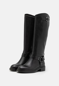 Czarne botki do kolan wykonane z gładkiej skóry. Posiadają srebrną klamrę i detal ze skóry, okrągły czubek oraz niski blokowy obcas, zapewniający stabilność.