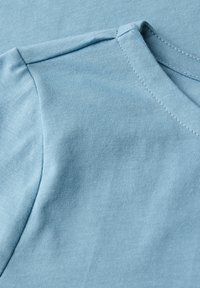 Lichtblauw katoenen t-shirt stof met een gladde textuur, met een ronde halslijn en korte mouwen. Zichtbare stikseldetails.