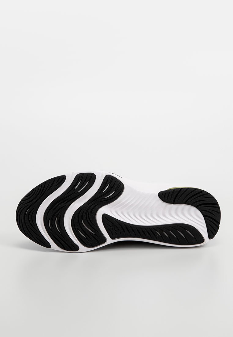 Semelle de sneaker blanche avec des motifs de crampons noirs en vagues pour l'adhérence, vue par le dessous sur un fond clair.