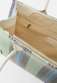 Borsa a tracolla multicolore con un esterno in tessuto intrecciato caratterizzato da strisce blu, verdi e rosse, e un interno beige con una tasca con zip.
