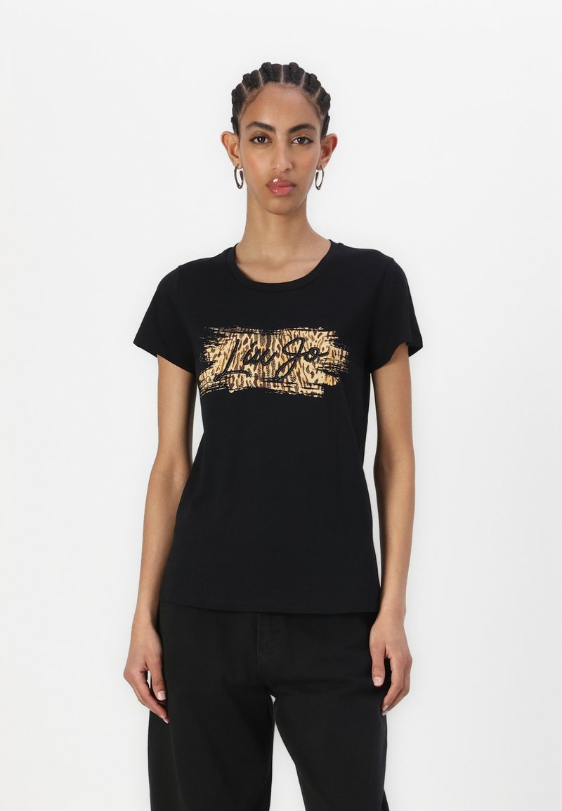 T-shirt nera in cotone con un logo in stampa animale dorata e un design testurizzato sul fronte. Maniche corte ecollo rotondo.