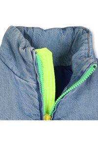 Γιακάς τζιν μπουφάν με φερμουάρ σε νέον κίτρινο και πράσινο. Διαθέτει απαλή υφή και αντίθετες λεπτομέρειες φερμουάρ. Η εσωτερική επένδυση είναι σκούρο μπλε.