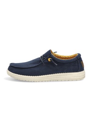 Zapato casual azul marino sin cordones, con suela beige, cordones elásticos ajustables y forro interior amarillo con estampado.