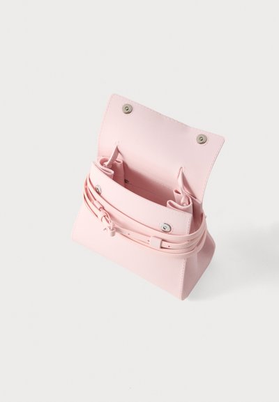 Μικρό ροζ ροδαλό τσαντάκι με ανοιχτό καπάκι, που δείχνει το εσωτερικό και λεπτό λουρί τυλιγμένο μπροστά με ασημένια μεταλλικά κλεισίματα.