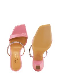 Roze gepatenteerde leren sandalen met een vierkante neus, enkelband versierd met zilveren studs, en een blokhak. Glad beige voetbed.
