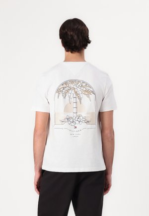 Bijela pamučna majica s grafikom palme i cvjetnim detaljima te natpisom "HILFIGER NEW YORK 1985" u suptilnoj paleti boja.