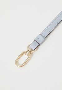 Cinturino in pelle blu chiaro con hardware in metallo dorato e dettagli di cucitura. Presenta un attacco a clip per una chiusura sicura.