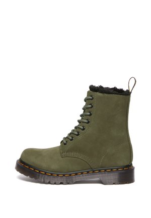Green suede ankle boot with black faux fur lining, round toe, 8 eyelets, green laces, and a black outsole with orange stitching.
