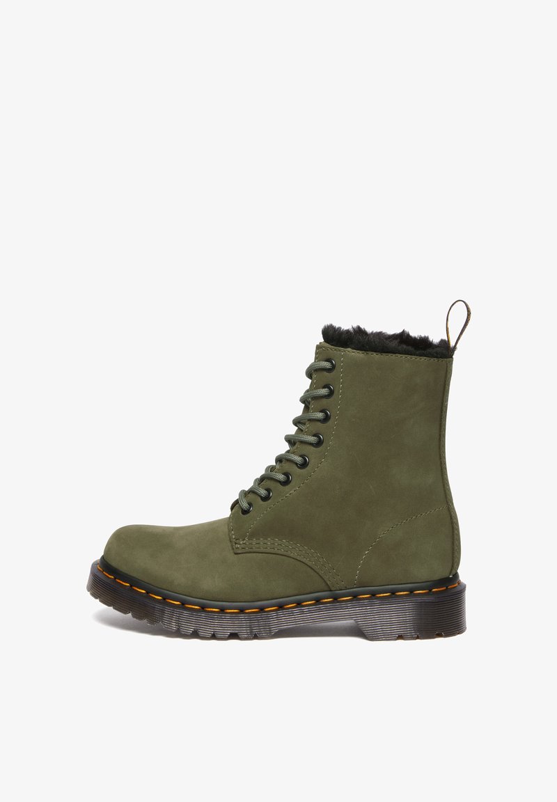 Groene suède enkelboot met zwarte neppelse voering, ronde neus, 8 oogjes, groene veters en een zwarte buitenzool met oranje stiksels.