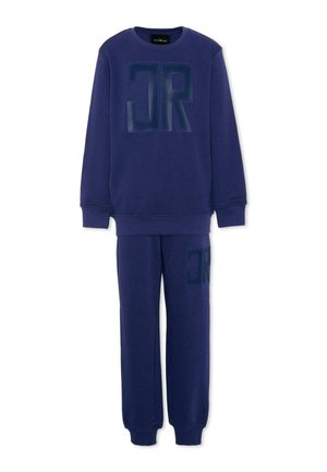 Granatowa bluza i dopasowane spodnie dresowe z dużymi ciemnymi teksturowanymi literami "JR" na klatce piersiowej i górnej części uda.