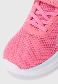 Rausvaišis tinklinis sportbačiai su tekstūruotu paviršiumi, turintys kontrastingus šviesiai mėlynus akcentus, apvalią noselę ir plokščias raišteles. Apačioje yra balta padas.