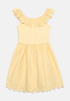 Gul ærmeløs kjole med flæset øjleblonde ved halsudskæring og kant, med blomstermønstrede udskæringer og et sammensyet skørt.