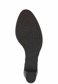 Semelle d'une chaussure habillée noire avec une semelle en caoutchouc texturée à l'avant et un talon lisse.