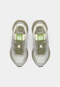 Αθλητικά παπούτσια από γκρι ανοιχτό δίχτυ με πράσινες και κρεμ λεπτομέρειες, με στρογγυλά κορδόνια, υφή στα πλευρά και λαστιχένια σόλα με ελαφριά καμπυλότητα.