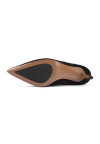 Zapato de tacón alto de ante negro visto desde la suela, con punta afilada y suela marrón que presenta un elemento antideslizante negro.